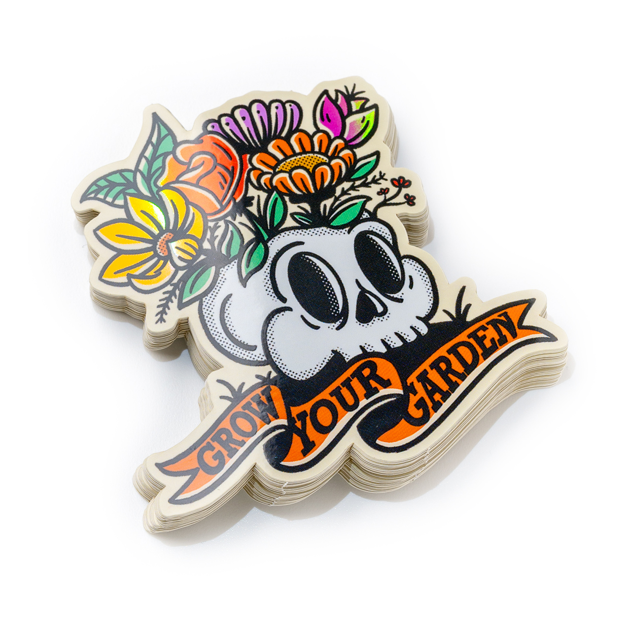 Die cut klistermärke med en dödskalle med färgglada blommor på toppen och en banderoll med texten "Grow Your Garden" under.