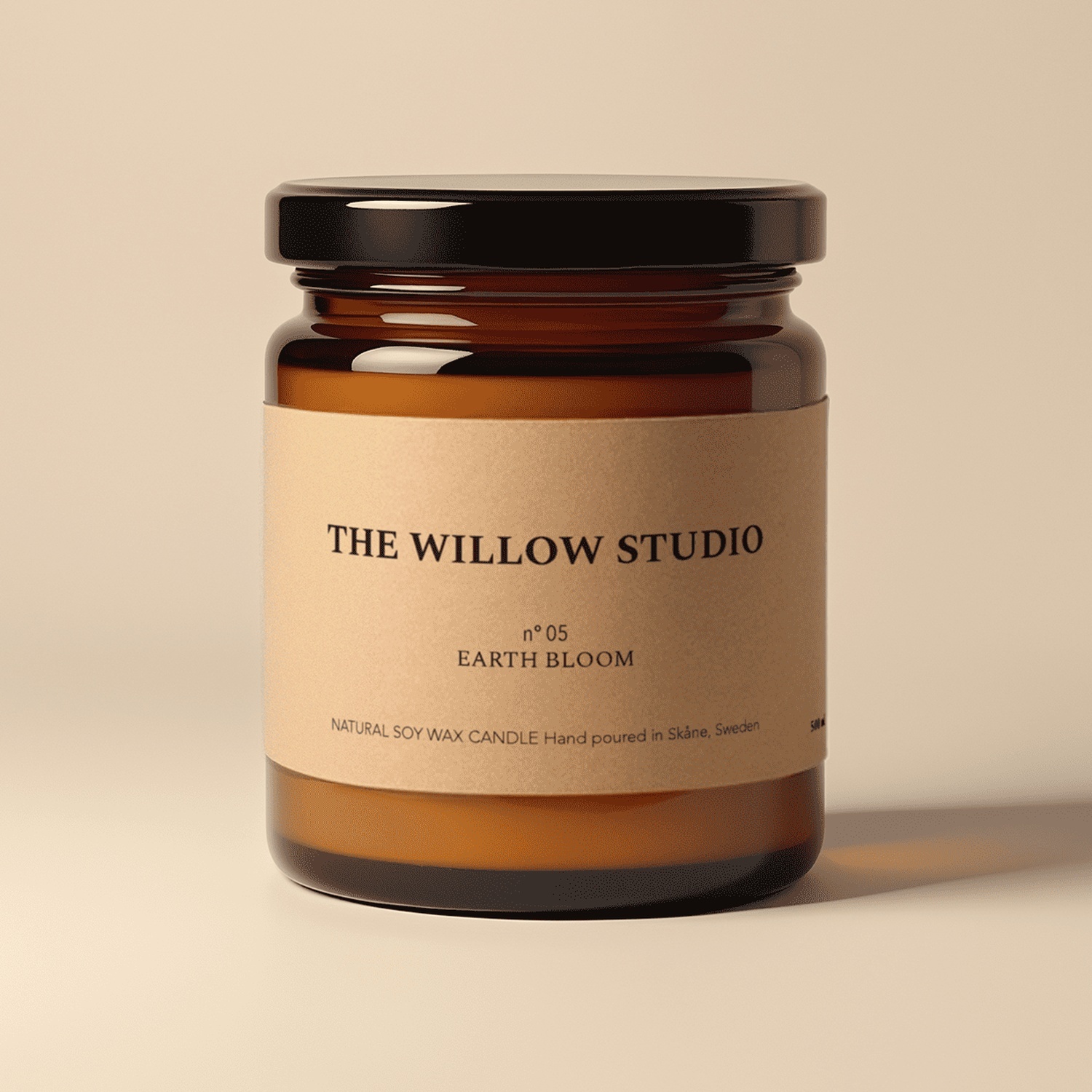 Ljusglas i bärnstensfärgat glas med en etikett i kraftpapper för The Willow Studios Earth Bloom, ett ljus av naturligt sojavax