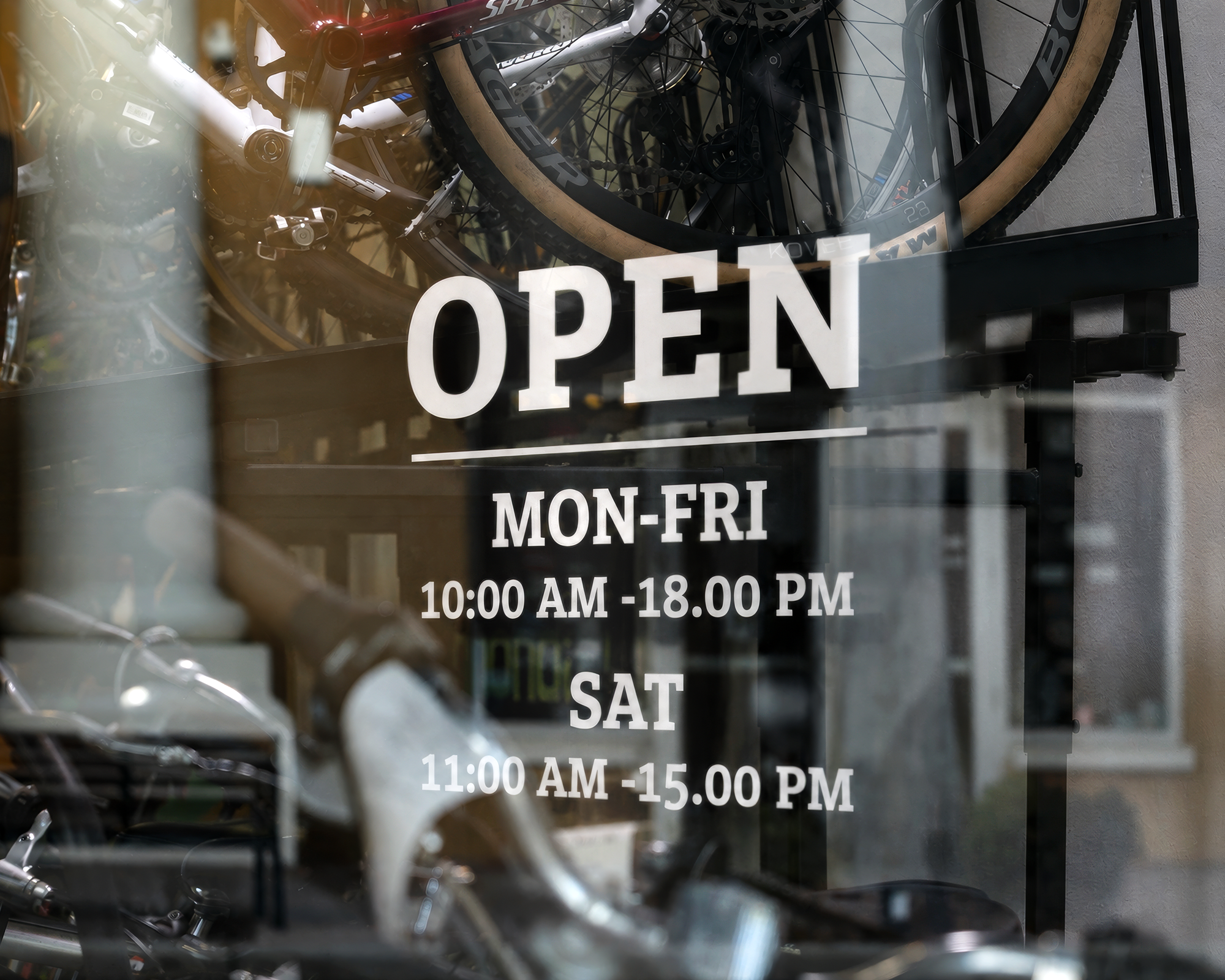 Storefront window decal displaying opening hours and business information.